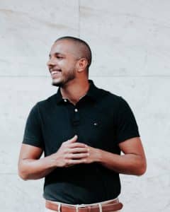 Man smiling side on in black polo shirt