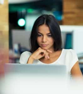 Woman looking intently at laptop